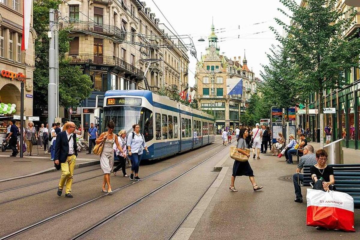 inimesed kõnnivad tiheda liiklusega linnatänaval trammiga