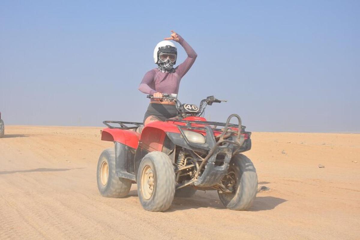 un uomo in sella a un quad nel deserto