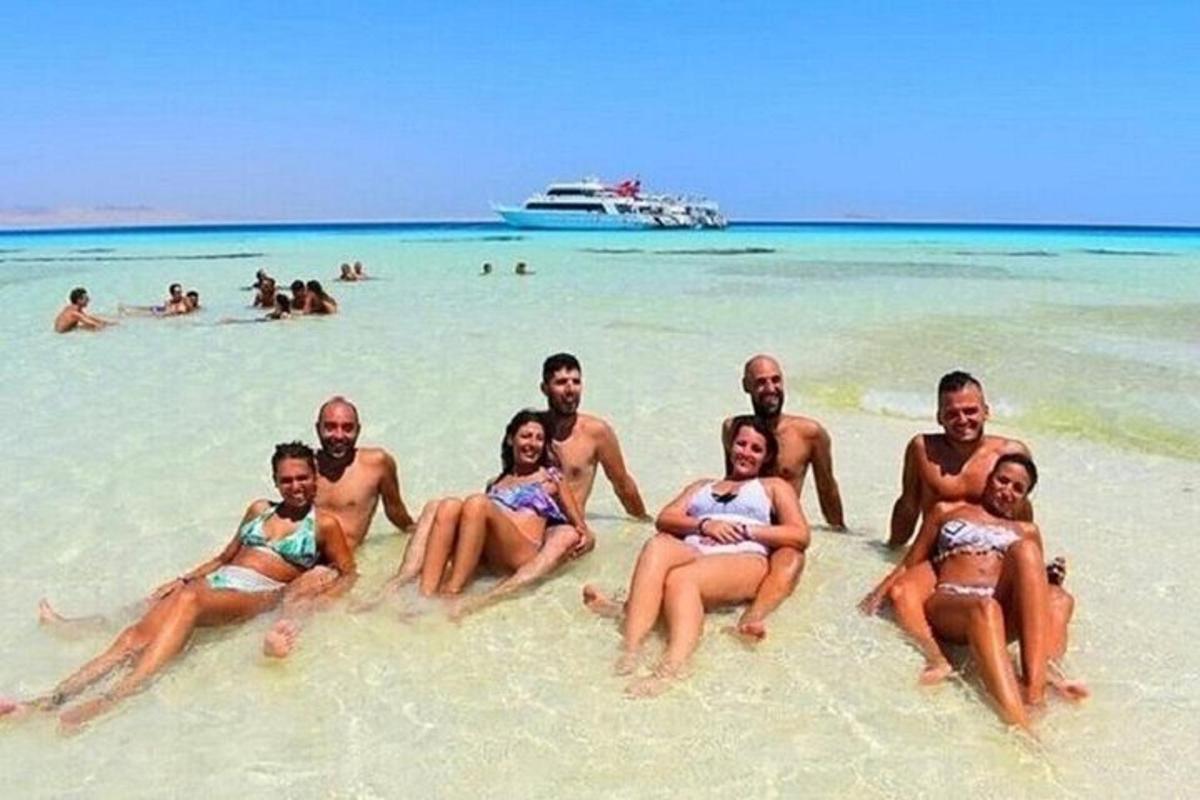 Un grupo de personas sentadas en la arena de una playa