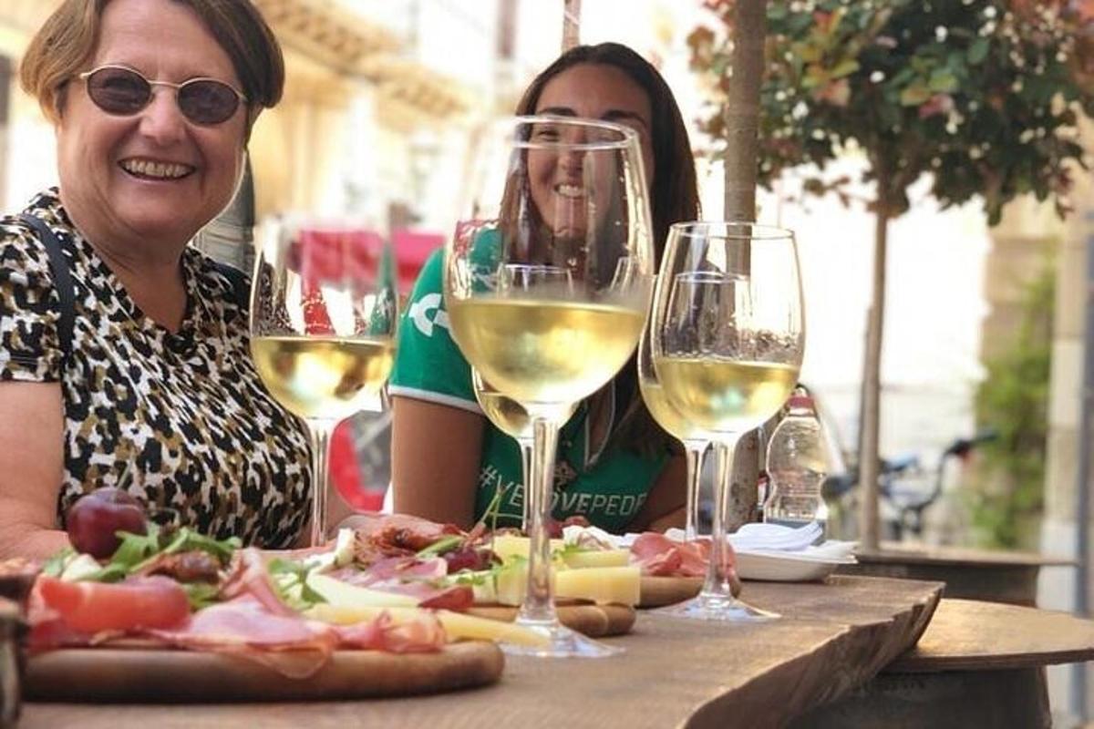 două femei așezate la o masă cu pahare de vin