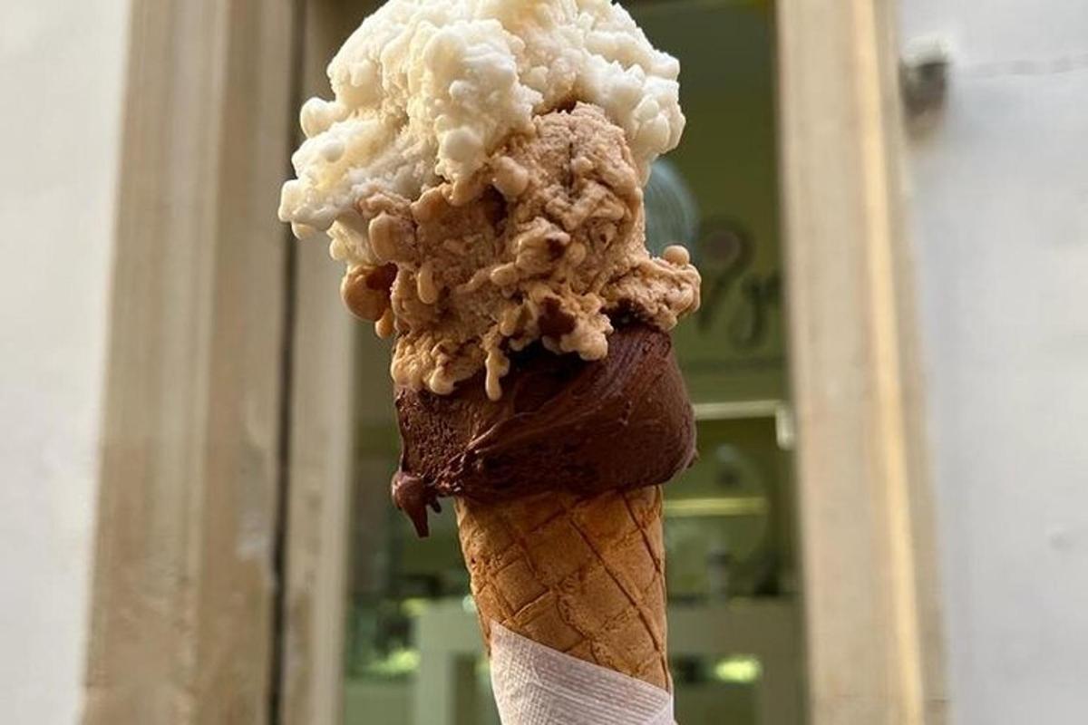 un cono gelato al cioccolato con una pallina di popcorn