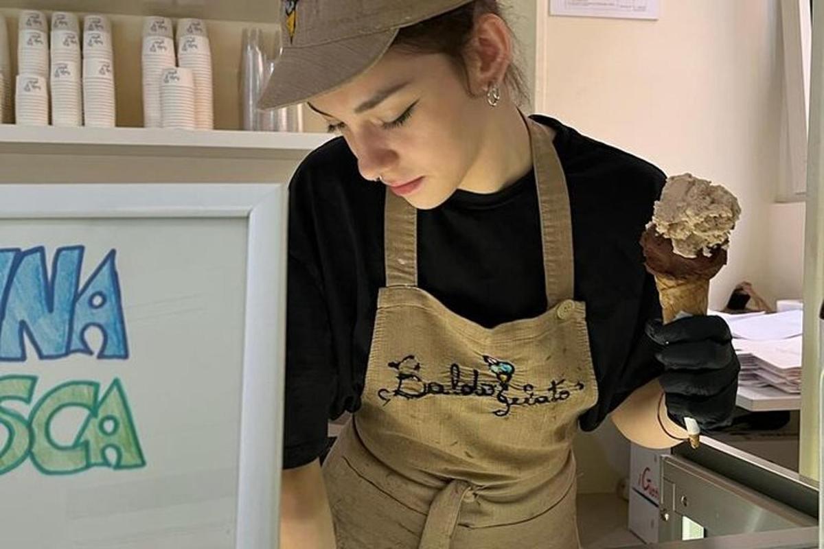 una donna che indossa un grembiule e tiene in mano un cono gelato