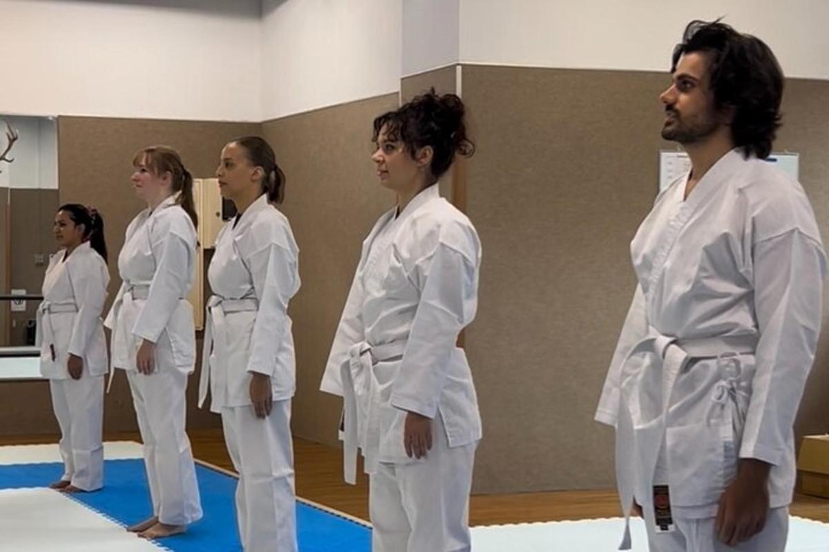 skupina ľudí v bielych džudistických uniformách v telocvični