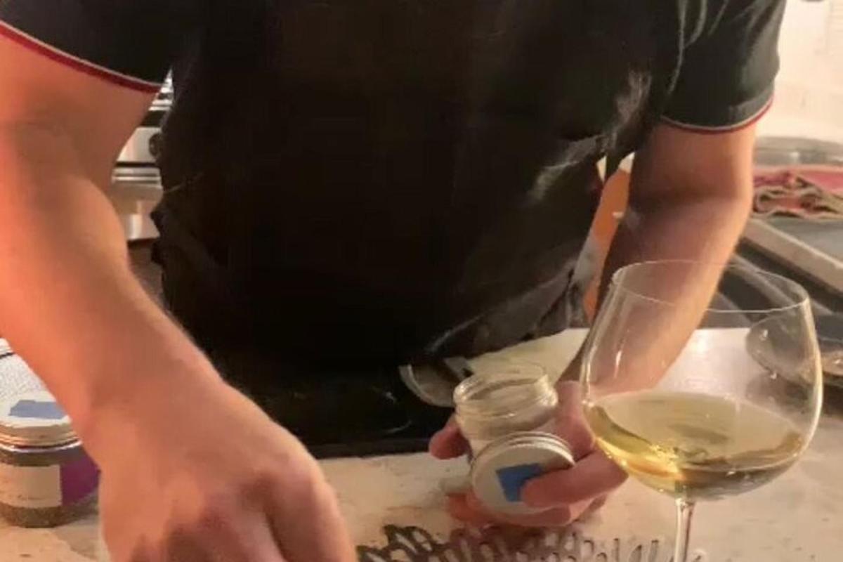 muž držící láhev vína a sklenici