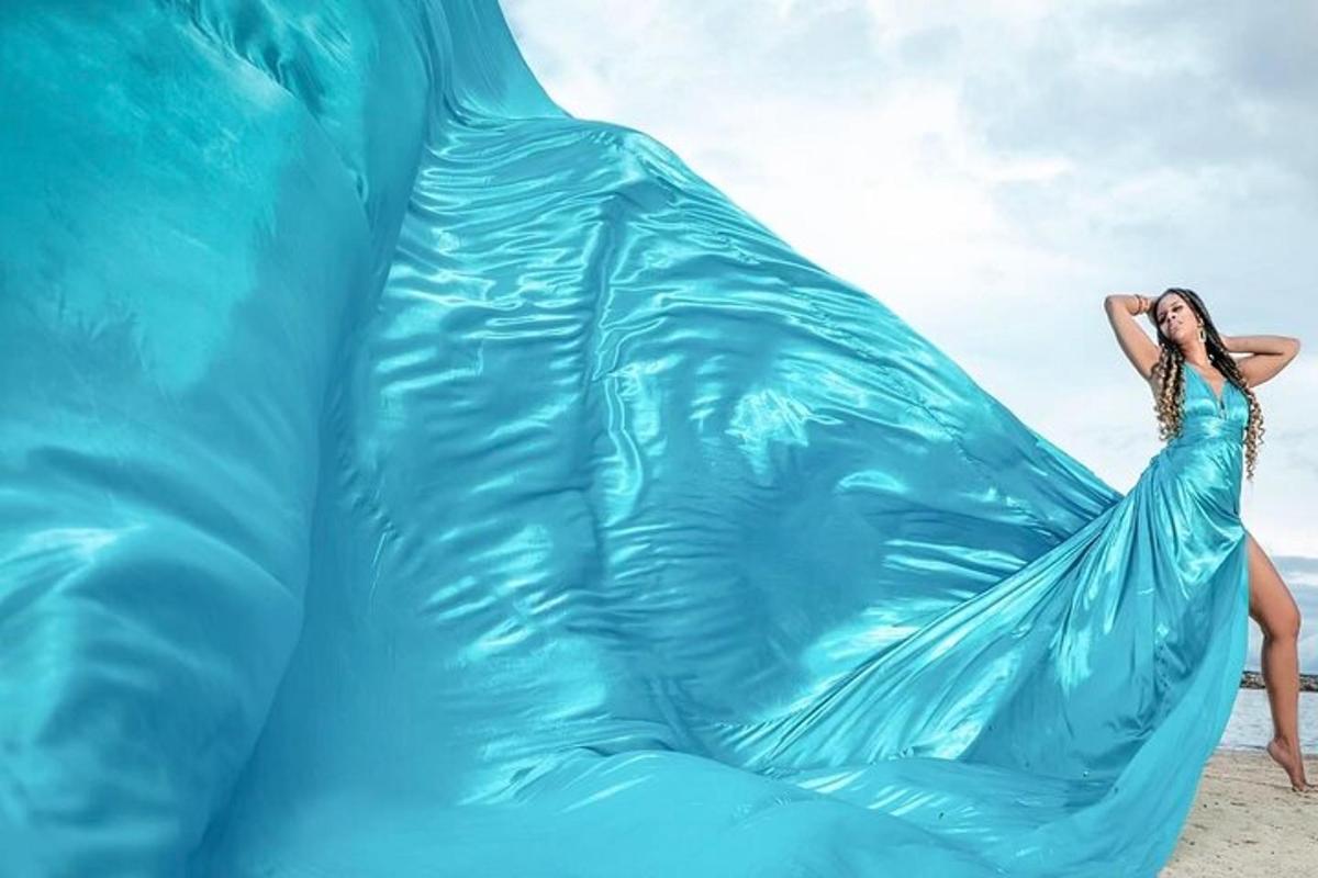 a woman in a blue dress is standing inside of an inflatableermott