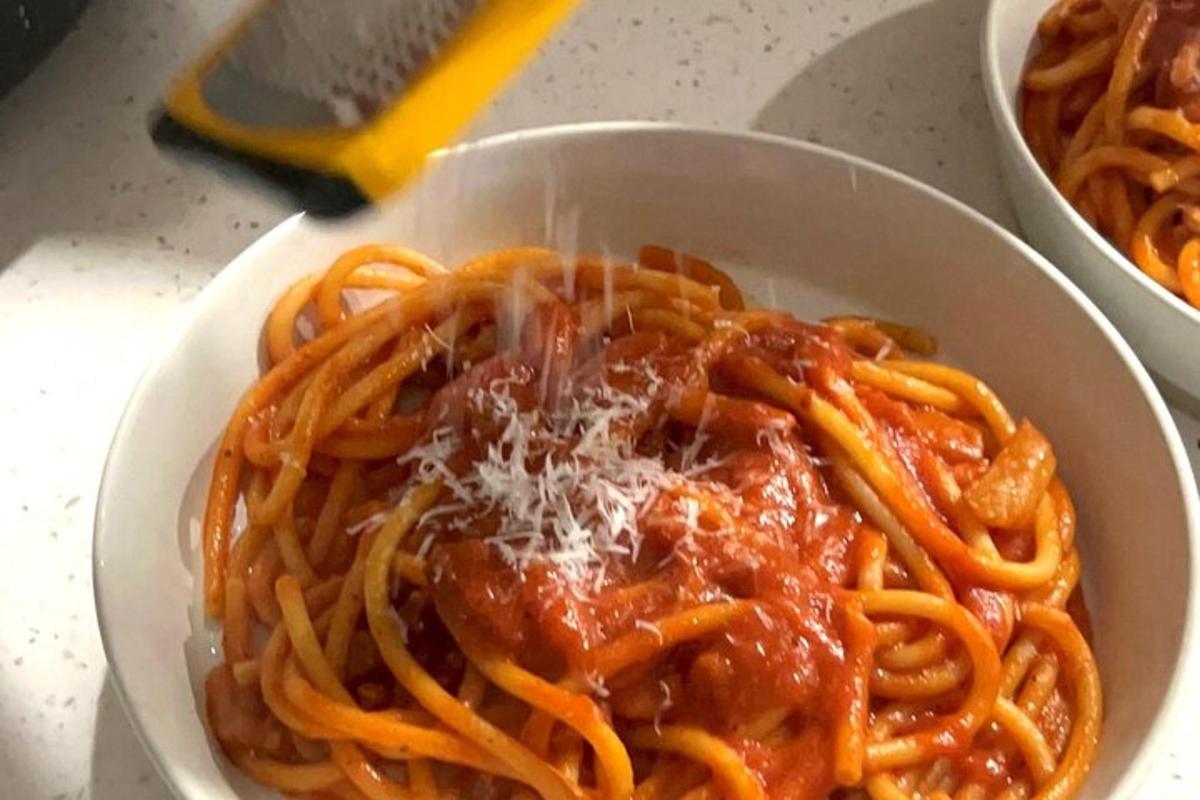 egy tál spagetti szósszal és sajttal az asztalon