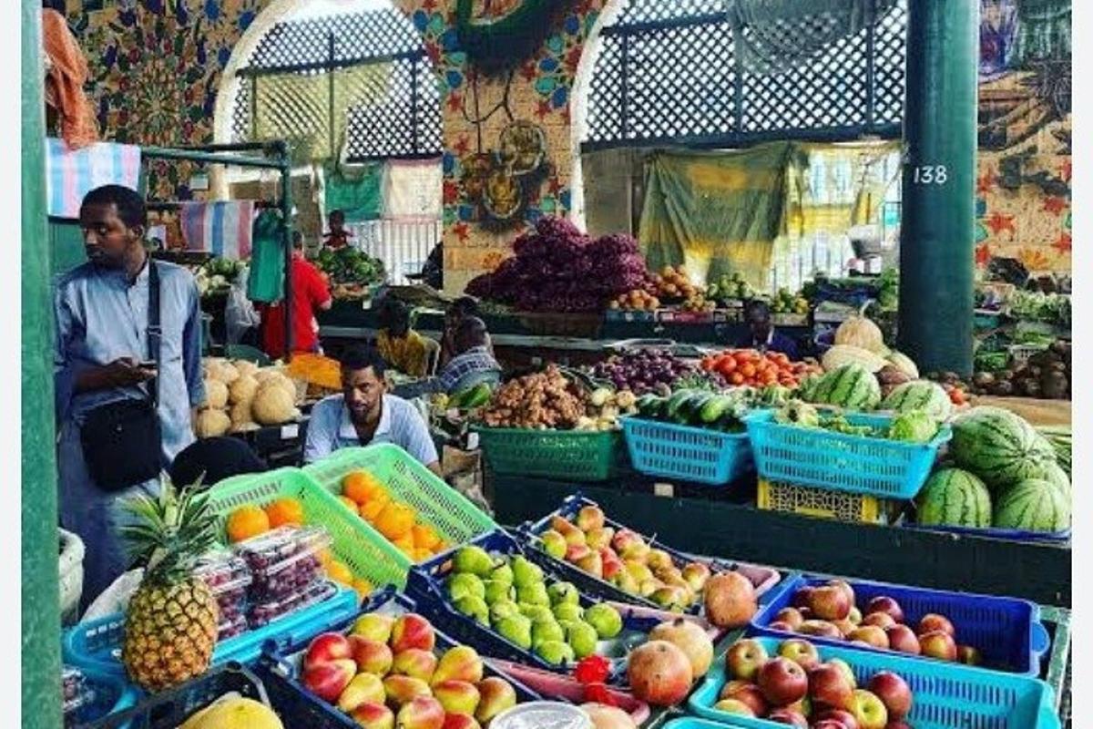 Два мушкарца стоје на пијаци са воћем и поврћем