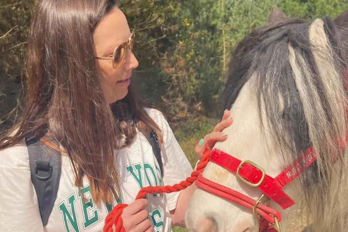 a woman is petting a white horse