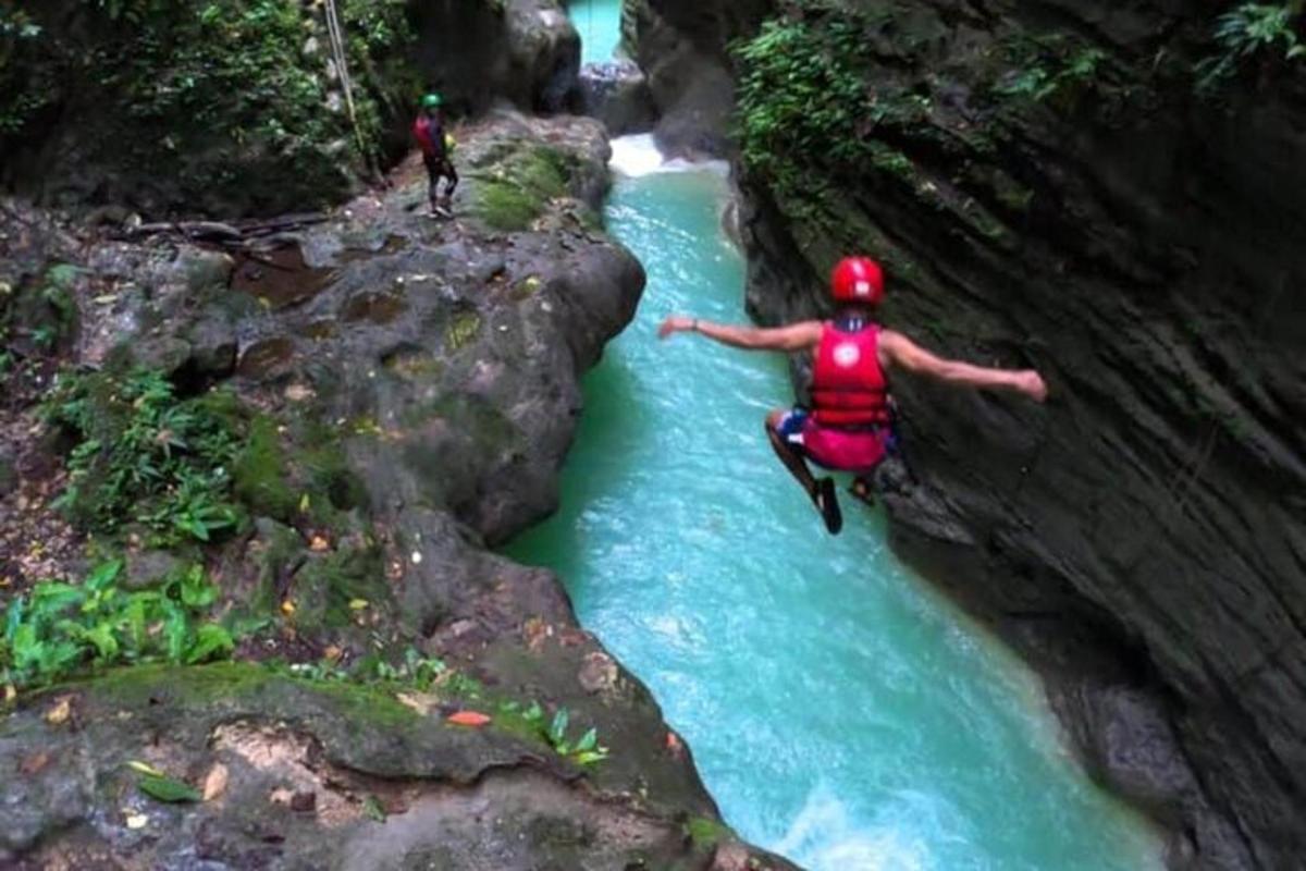 eine Person springt mit einem Floß in einen Fluss