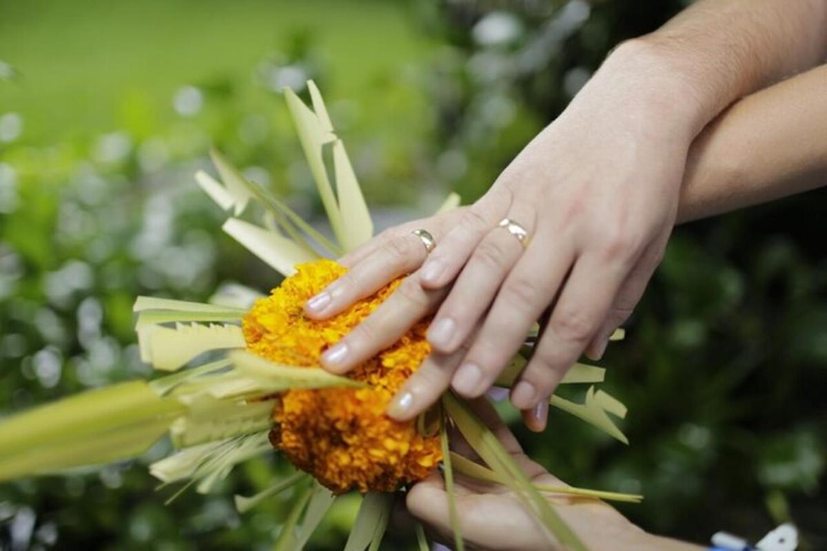 isang babae na may mga kamay sa isang bulaklak