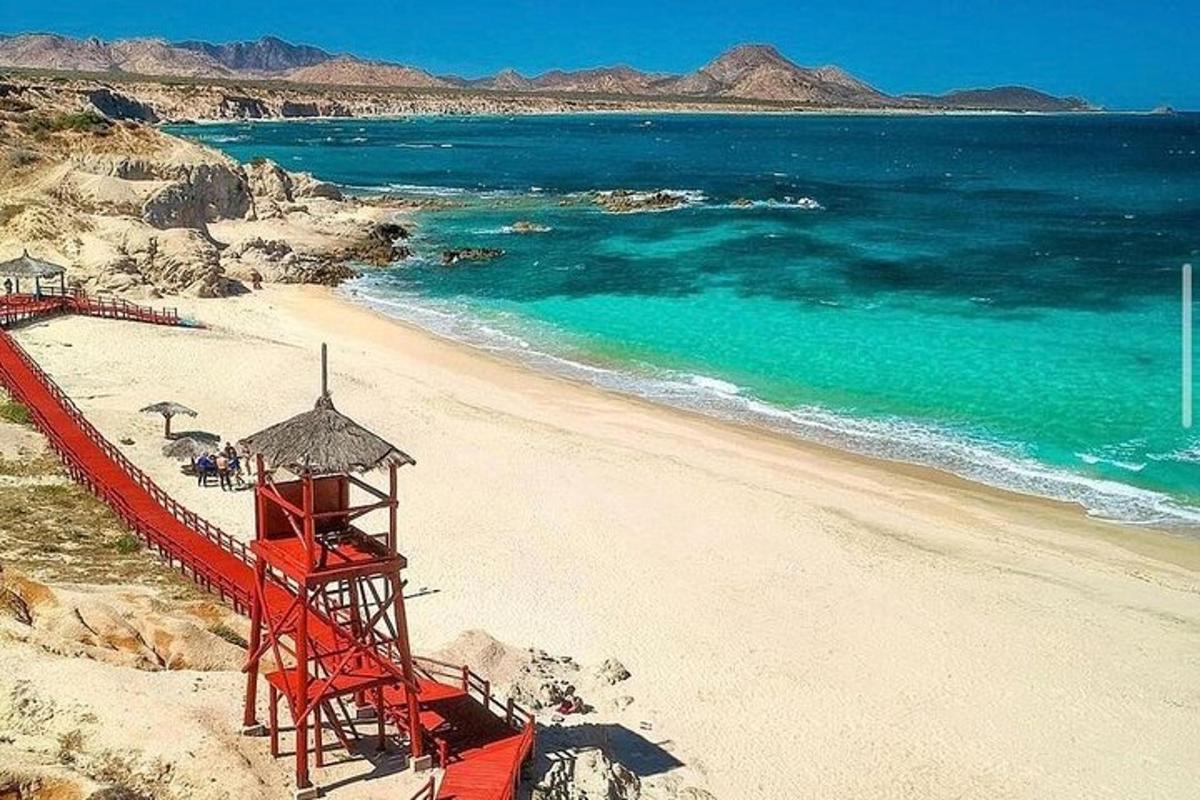 a red lifeguard tower on a beach with the ocean