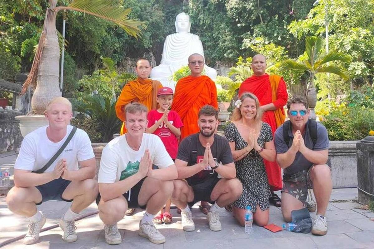 um grupo de pessoas posando em frente a uma estátua