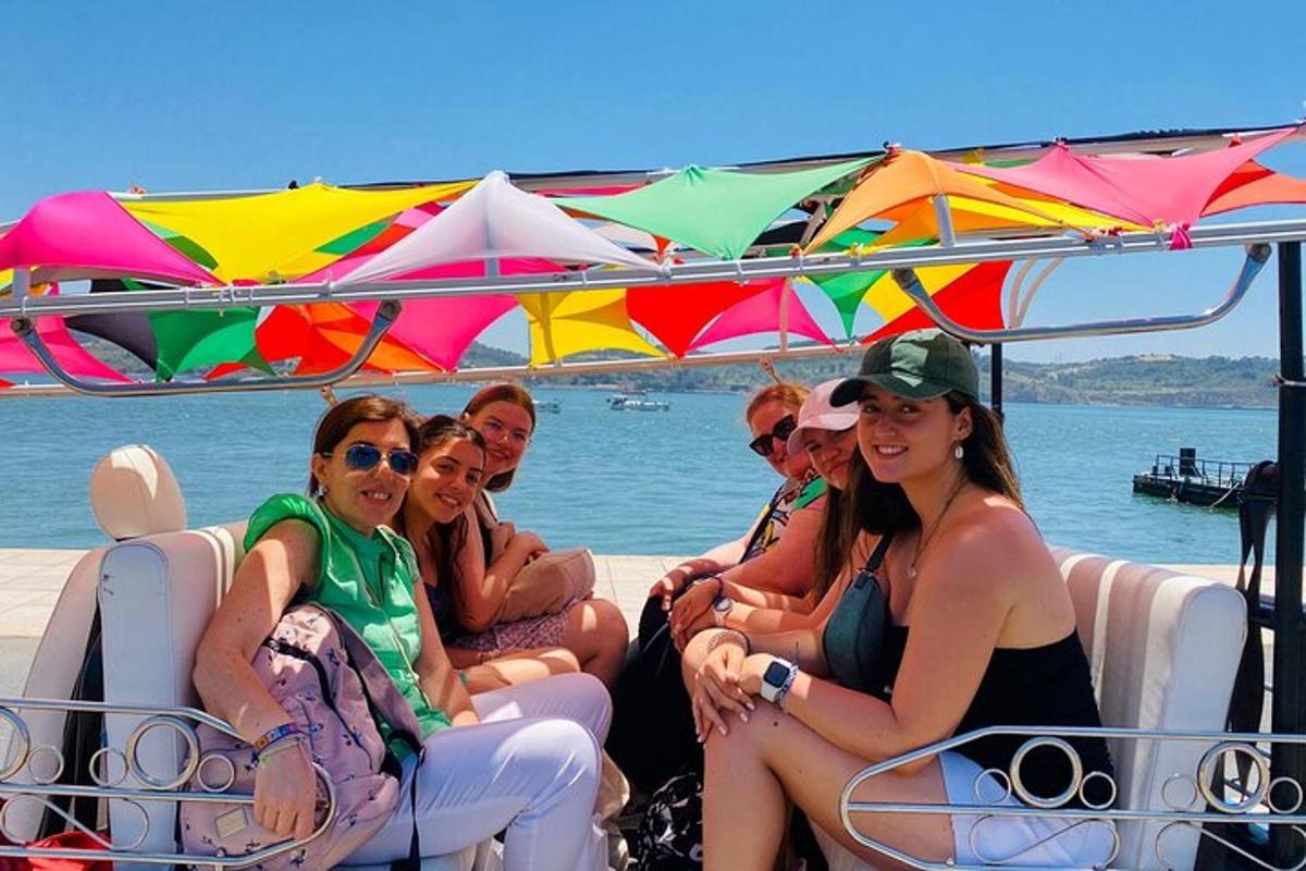 un gruppo di persone sedute su una barca con gli ombrelli