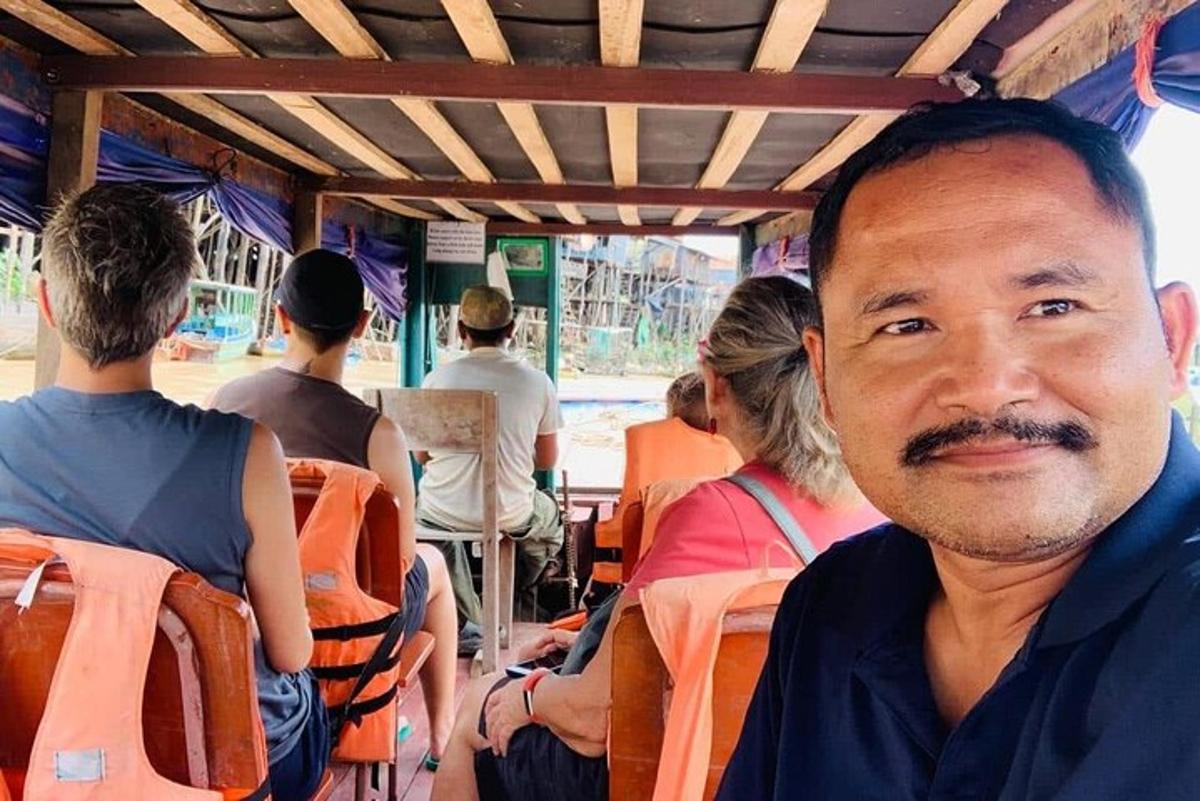 un home assegut en un autobús amb gent al fons