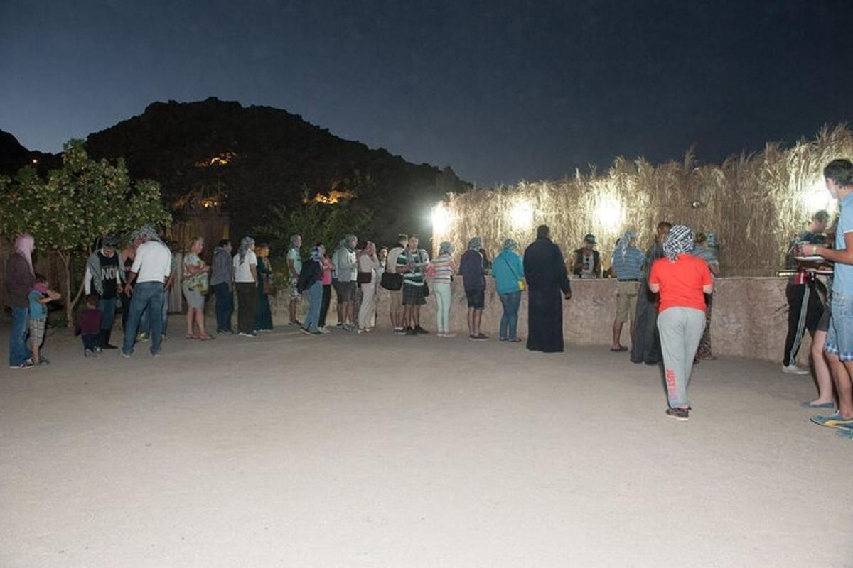 a crowd of people standing around a wall at night