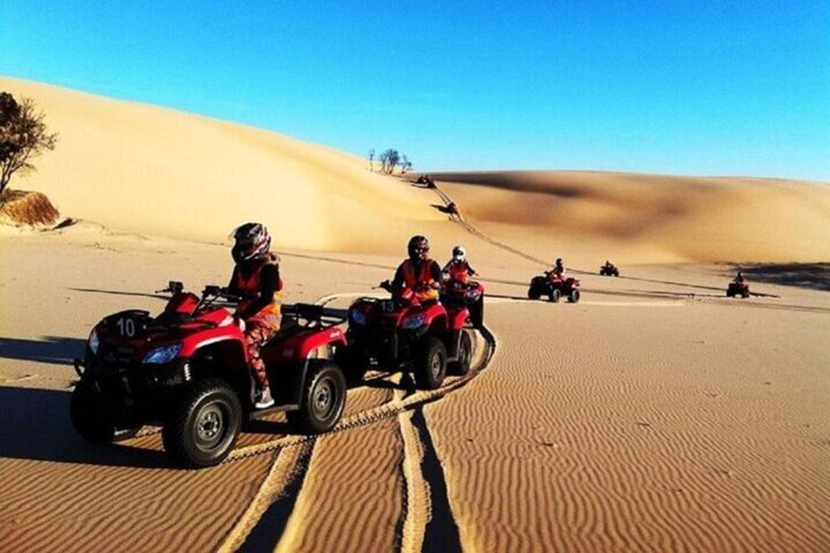 un gruppo di persone che guidano quad nel deserto