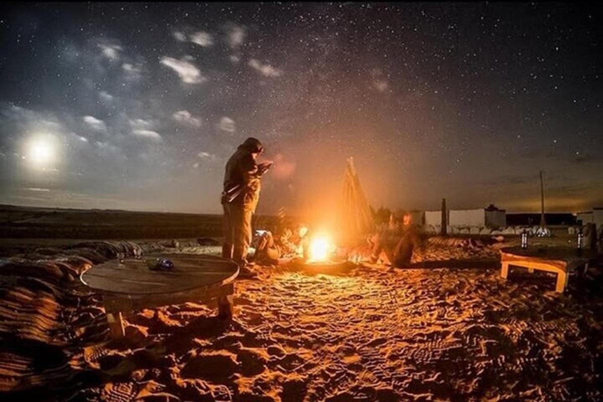un uomo in piedi davanti a un fuoco da campo