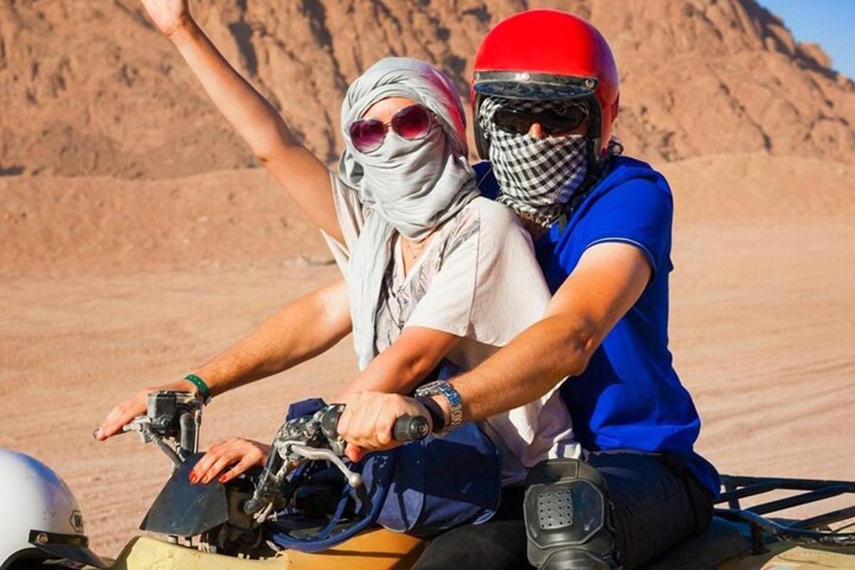 dva lidé jedoucí na motorce v poušti