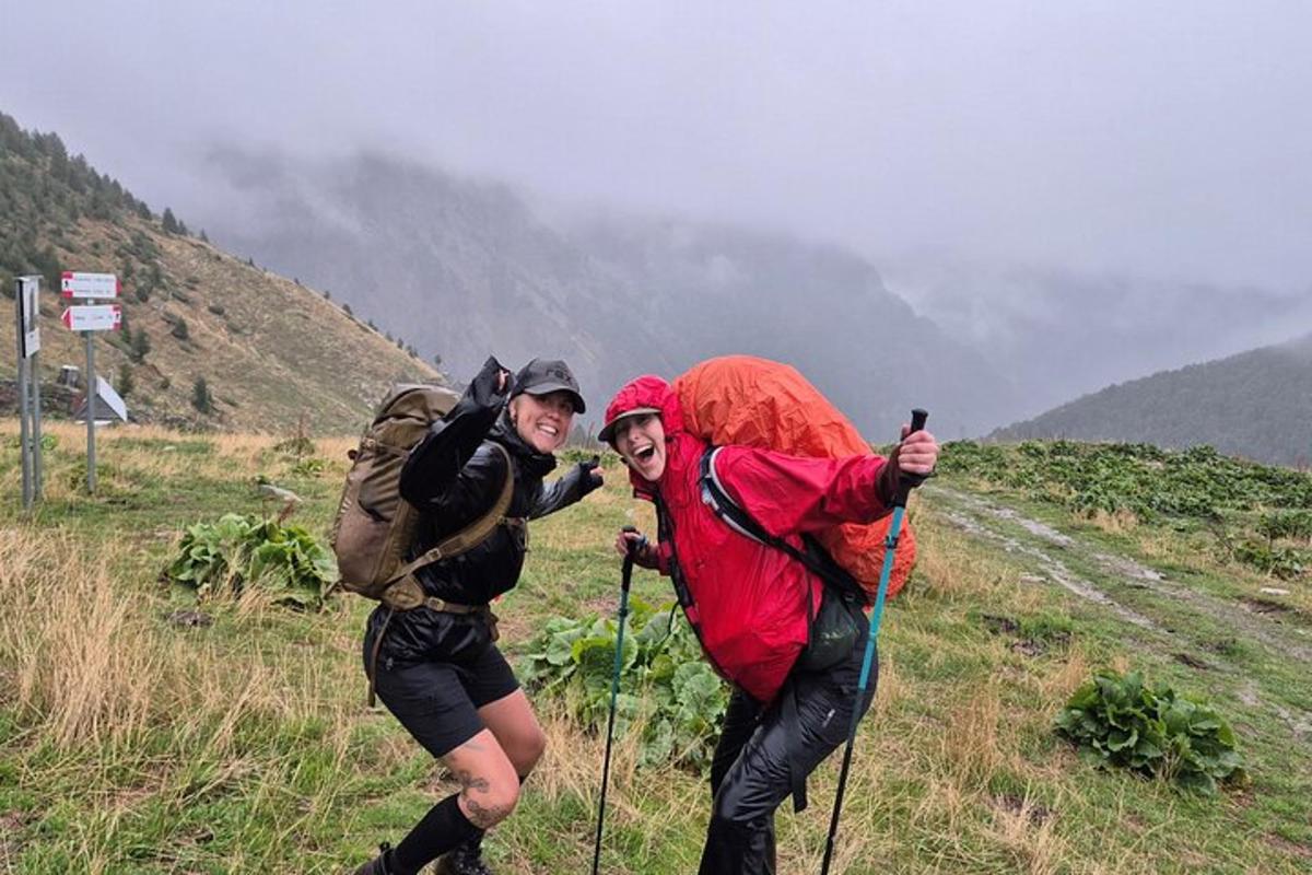 dua orang berjalan menaiki bukit di gunung