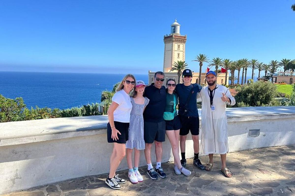 Un grupo de personas posando frente a un faro.