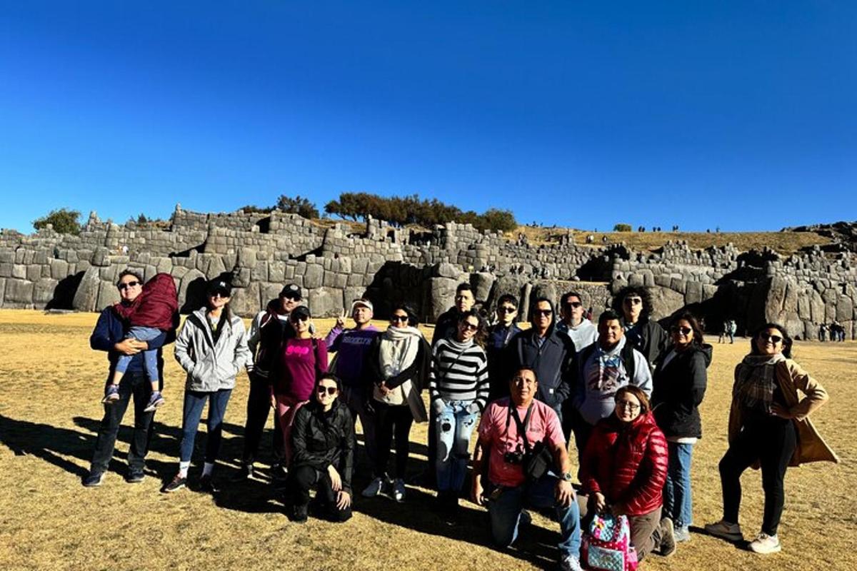 um grupo de pessoas posando para uma foto em frente a uma parede de pedra