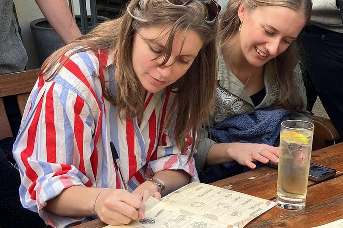 two girls sitting at a table looking at a paper