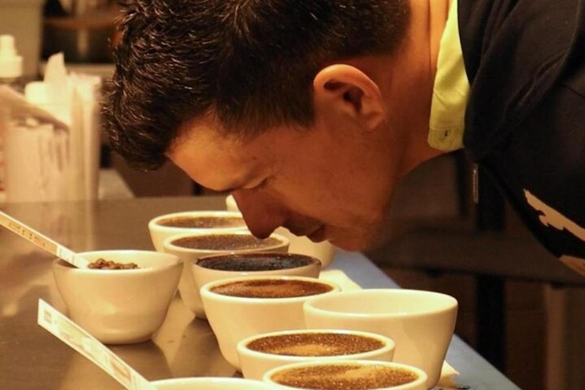 seorang lelaki sedang melihat ke bawah pada cawan kopi