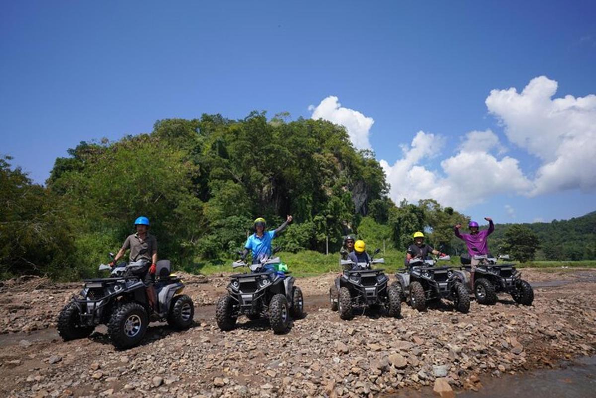 um grupo de pessoas em quadriciclos em uma estrada de terra