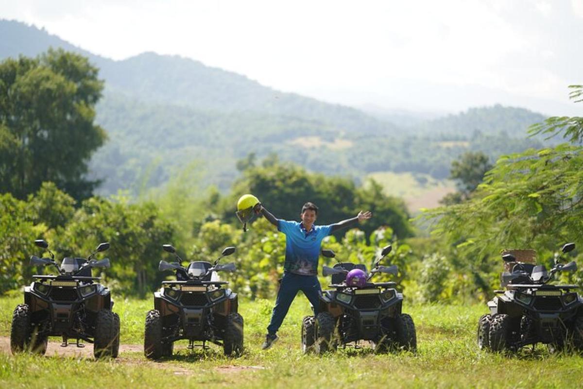 um homem segurando um frisbee na frente de dois quadriciclos