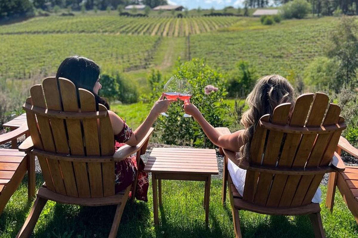 two people sitting in chairs holding up a glass of wine