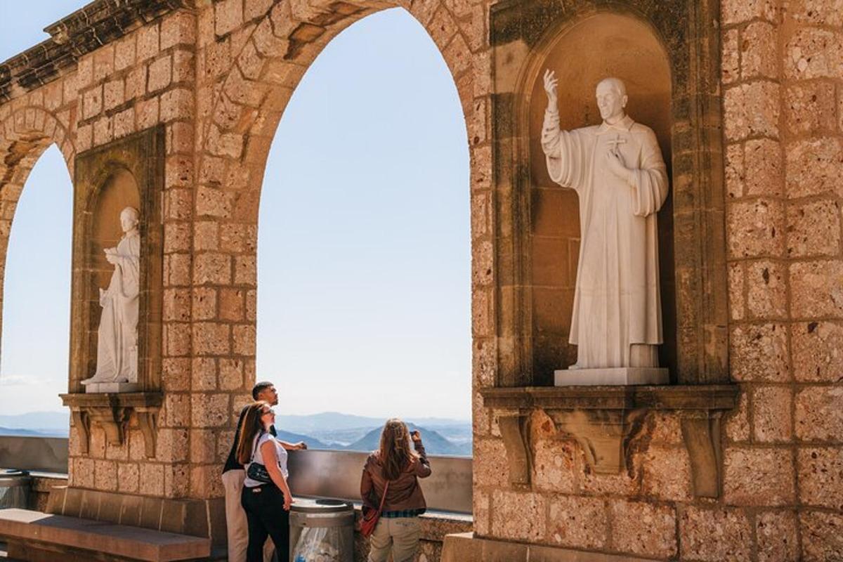 μια ομάδα ανθρώπων που στέκονται μπροστά σε ένα άγαλμα