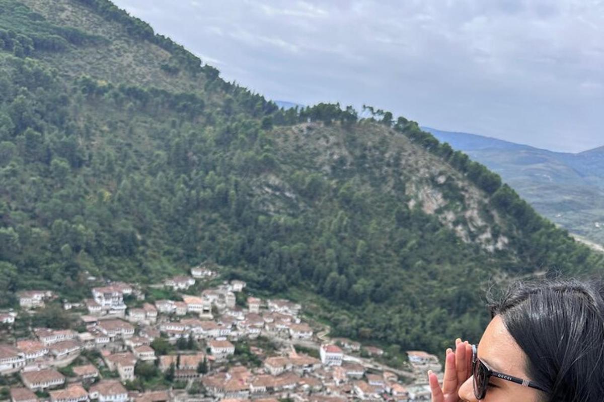 uma mulher em pé no topo de uma montanha