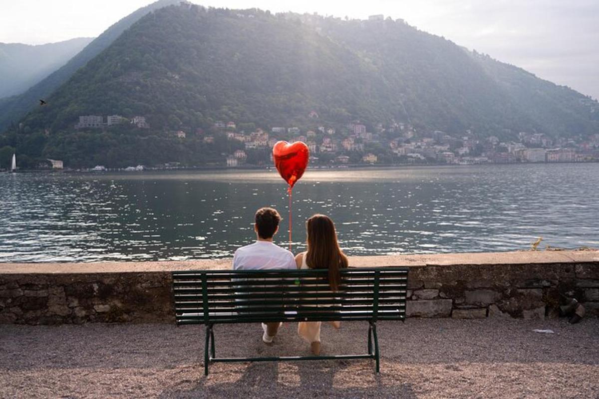a man and woman sitting on a bench with a heart balloon