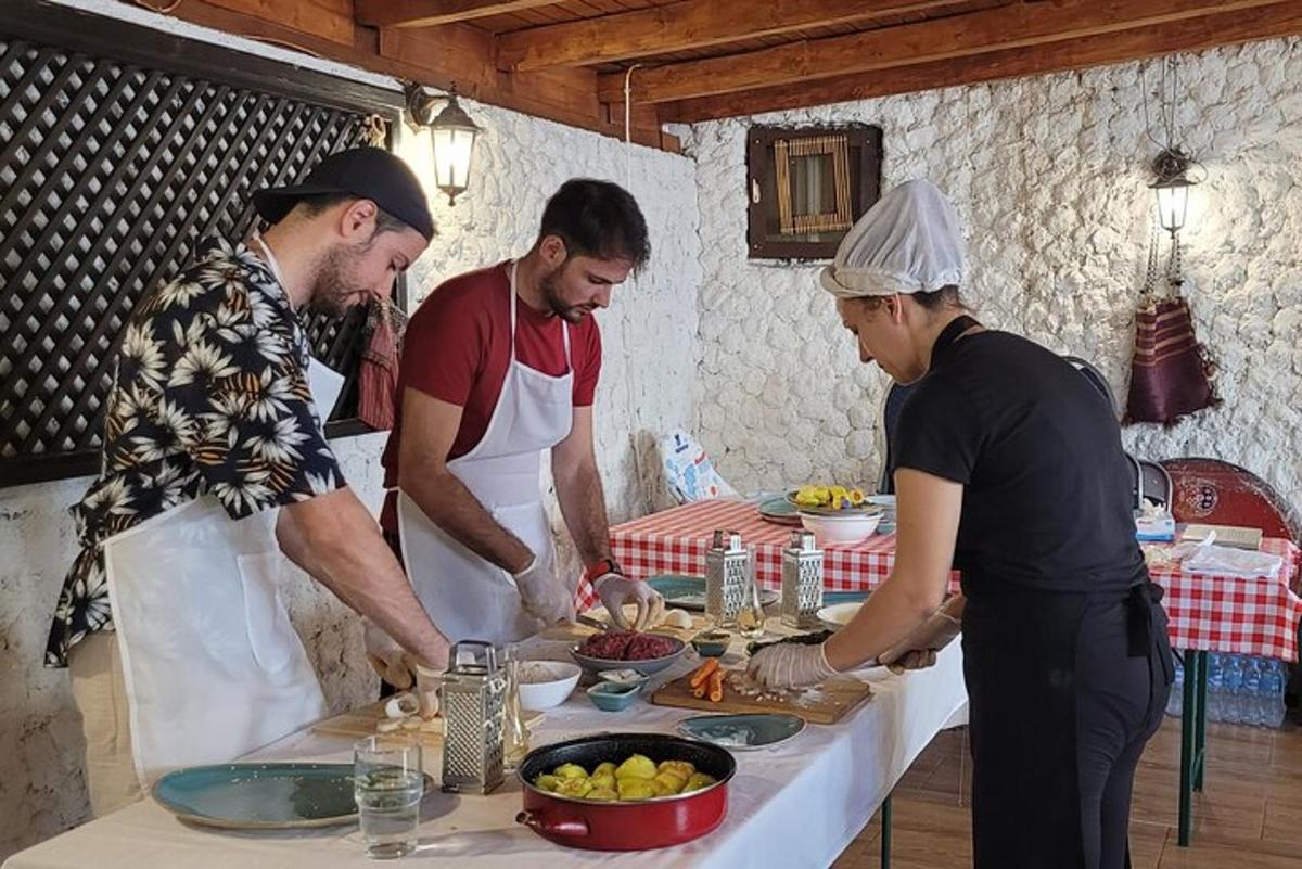 a group of three men standing around a table preparing food