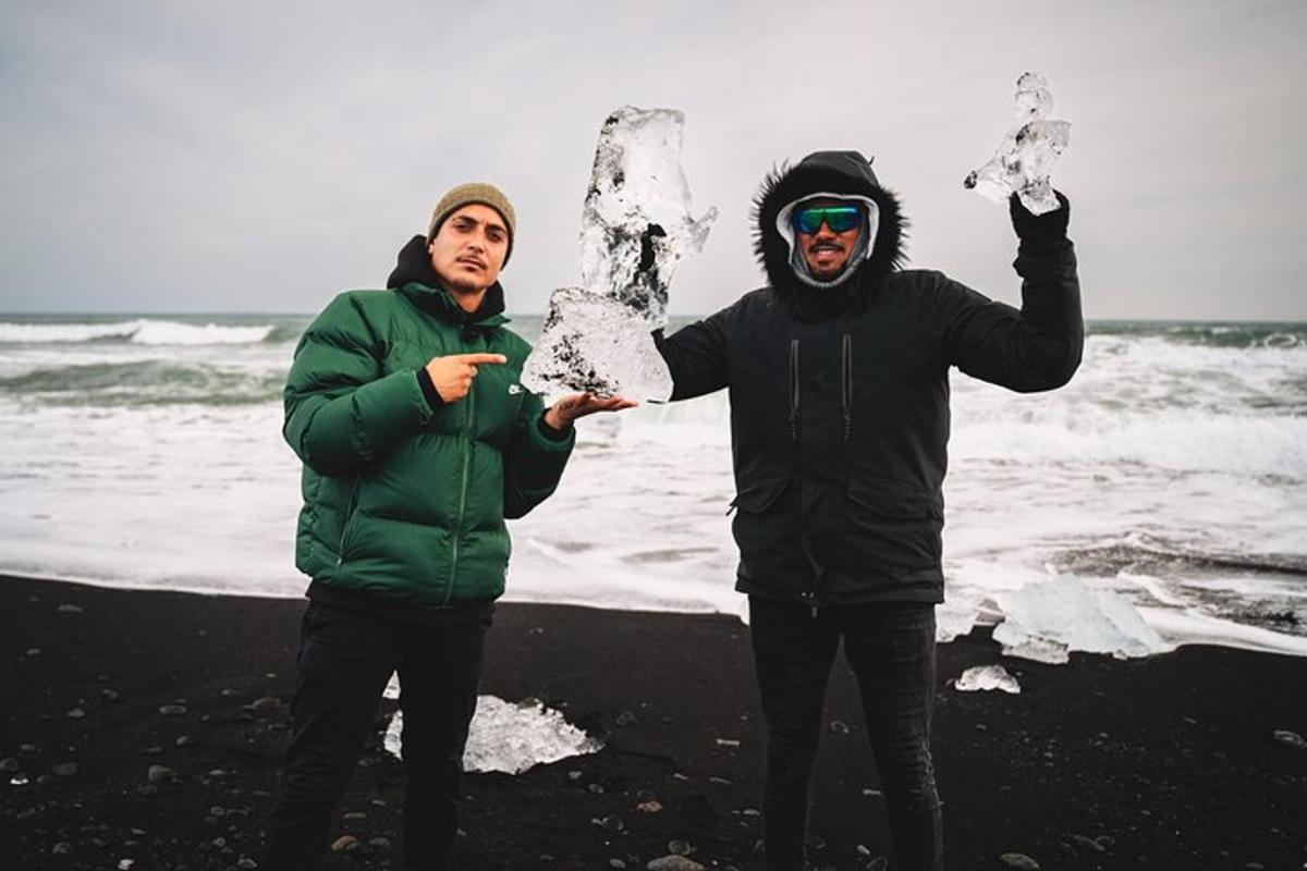 deux hommes debout sur la plage avec de la neige sur leurs mains