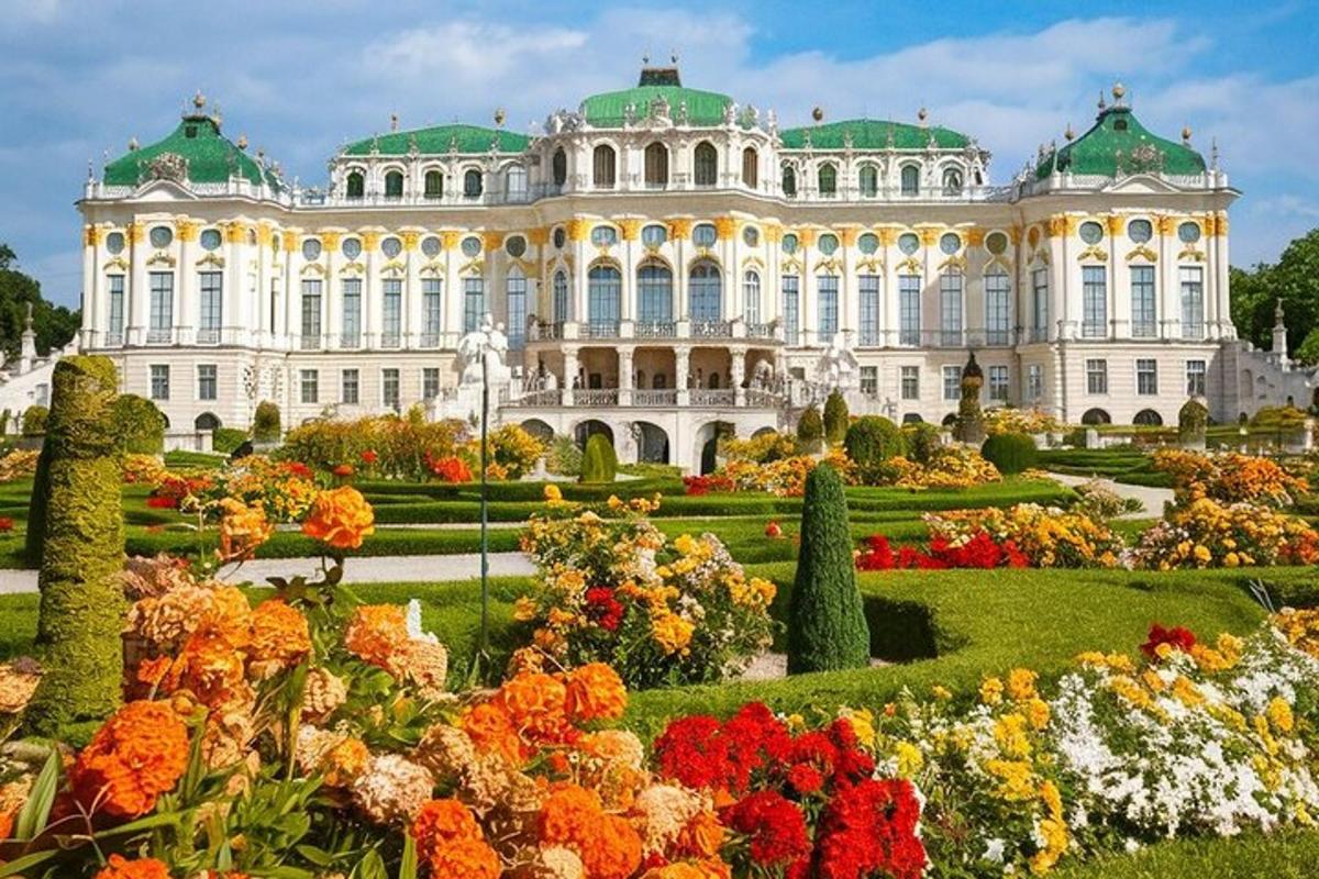 Un gran edificio blanco con jardín y flores.