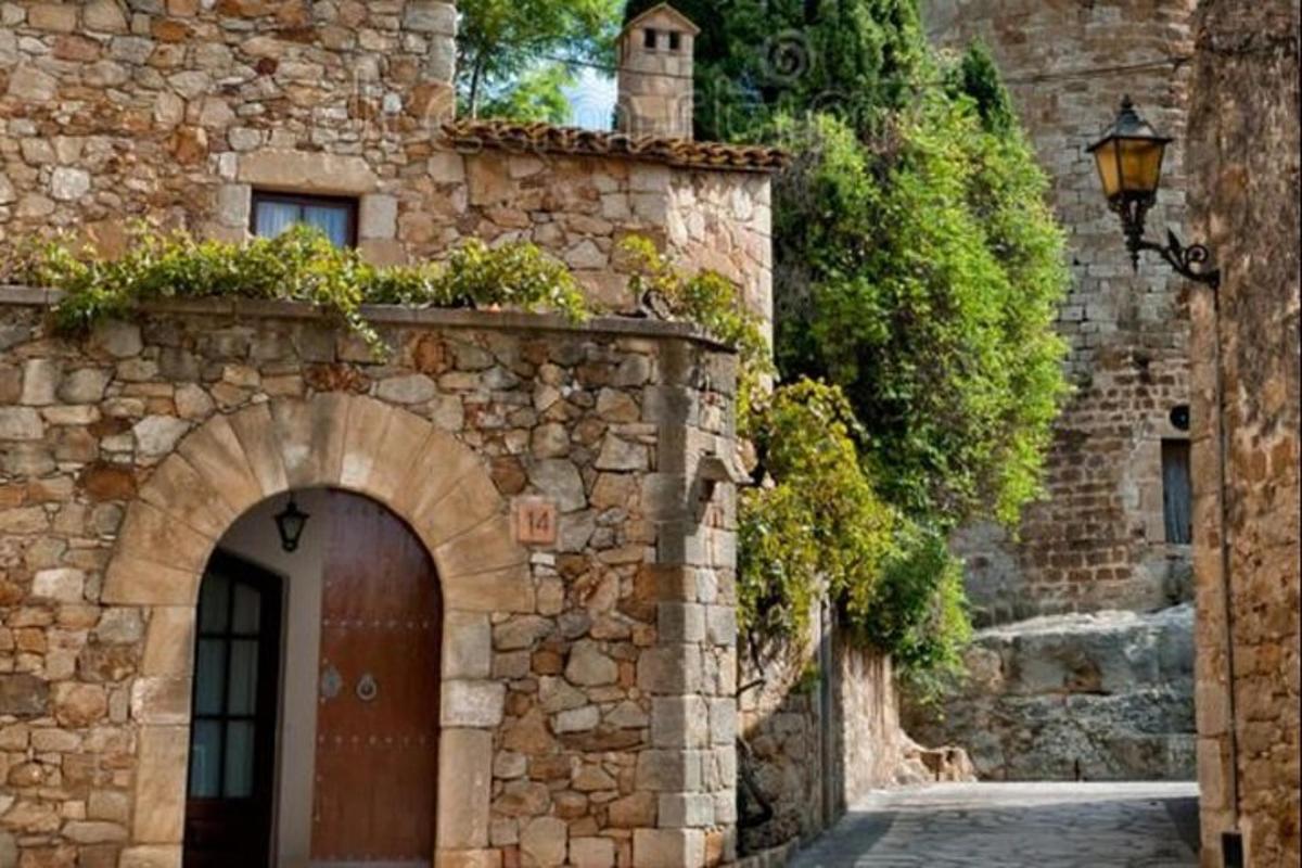 um edifício de pedra com uma porta marrom e uma rua