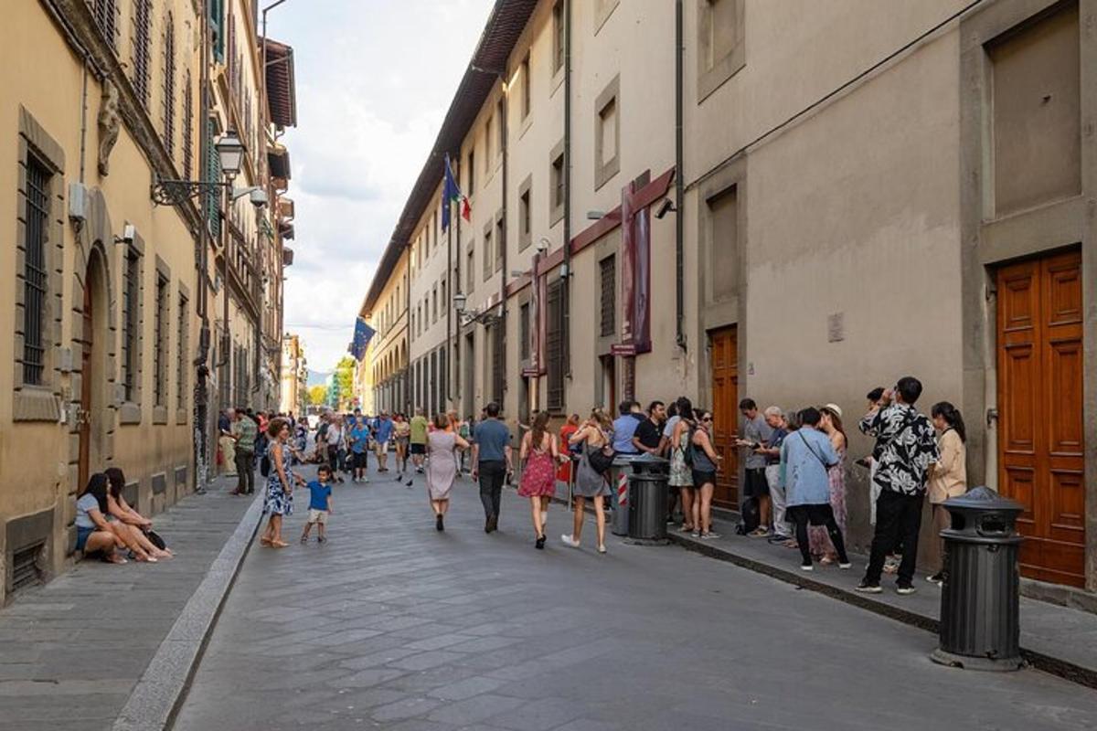 una multitud de gent caminant per un carrer amb edificis