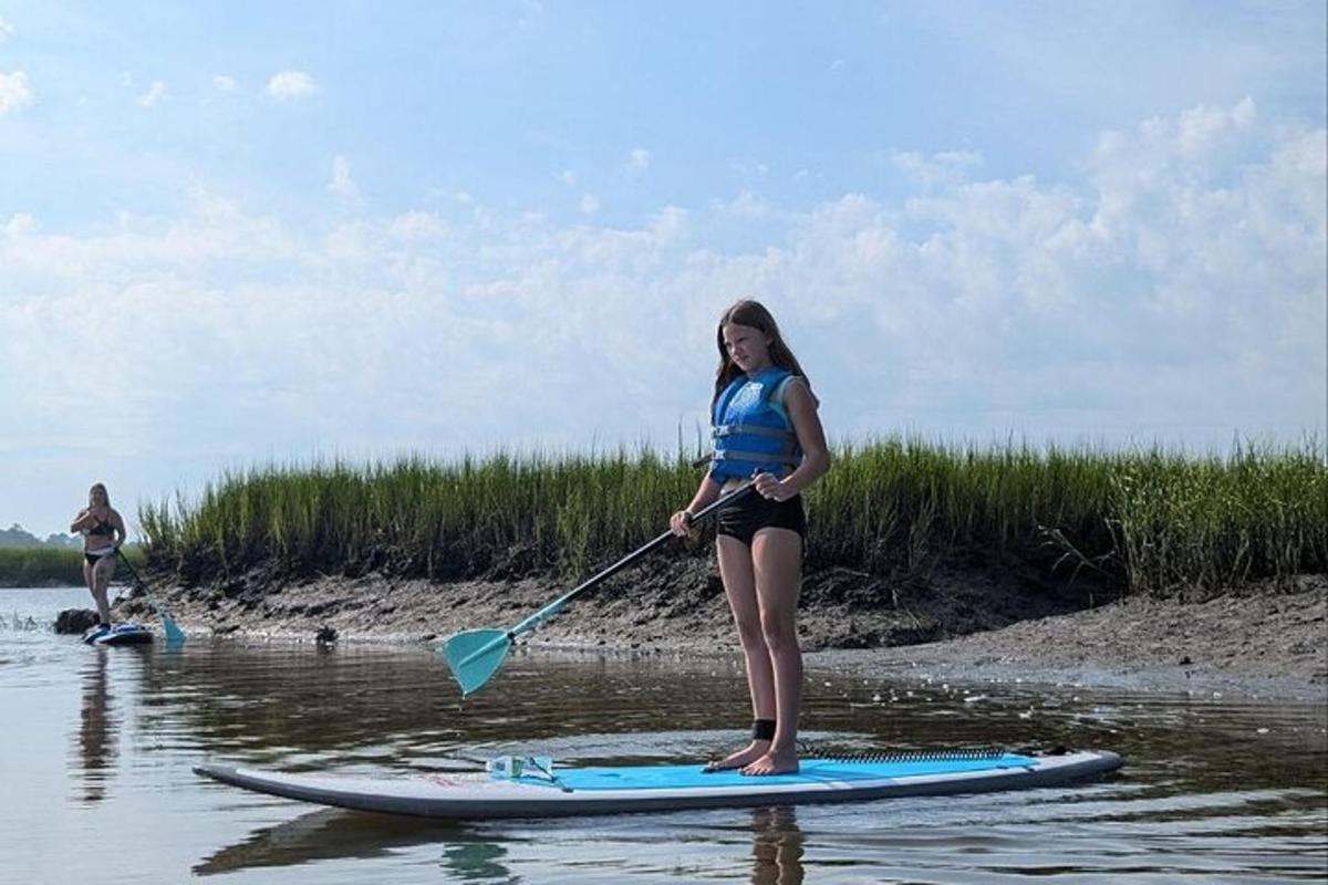 Una mujer parada sobre una tabla de remo en el agua