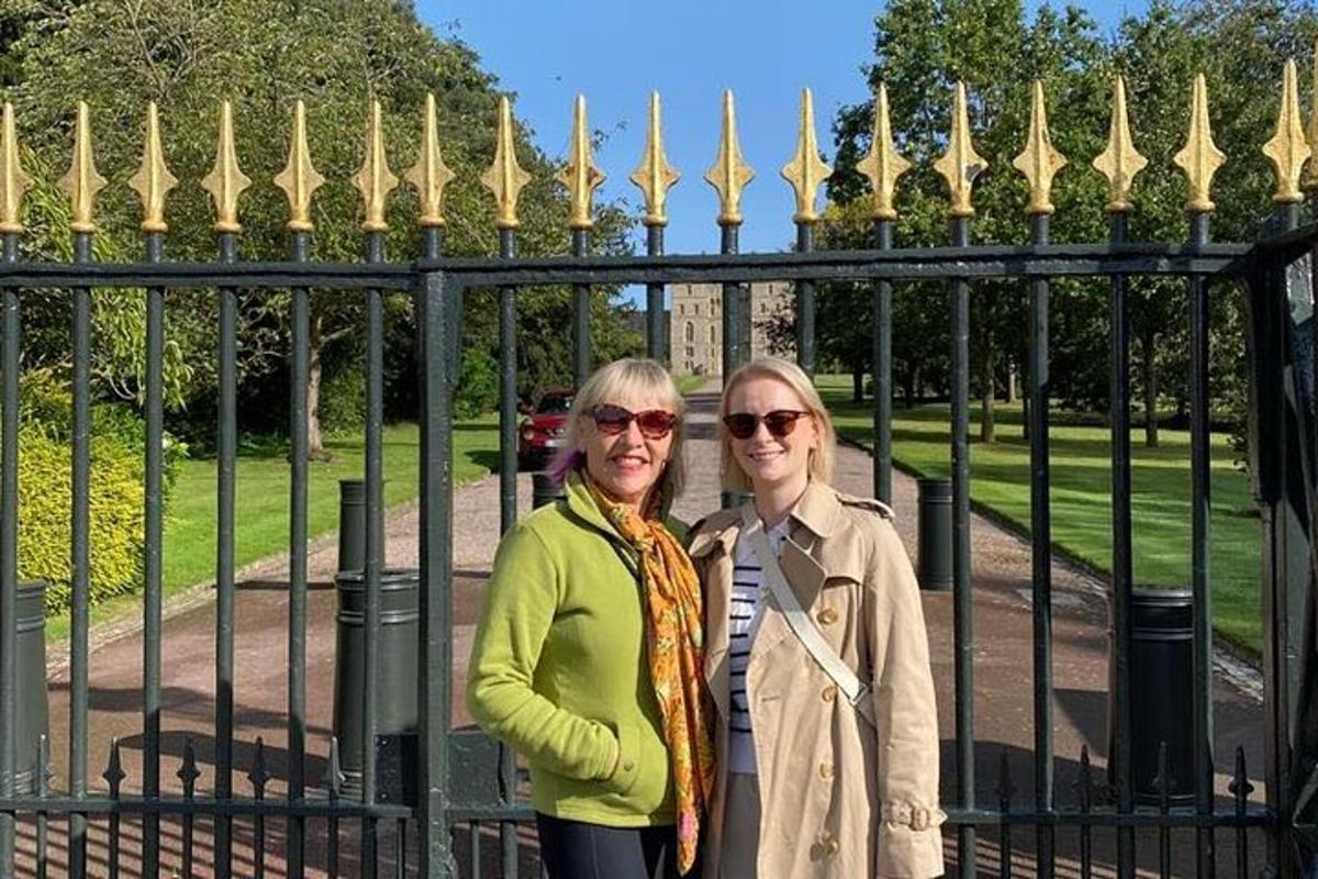 two older women standing in front of a gate