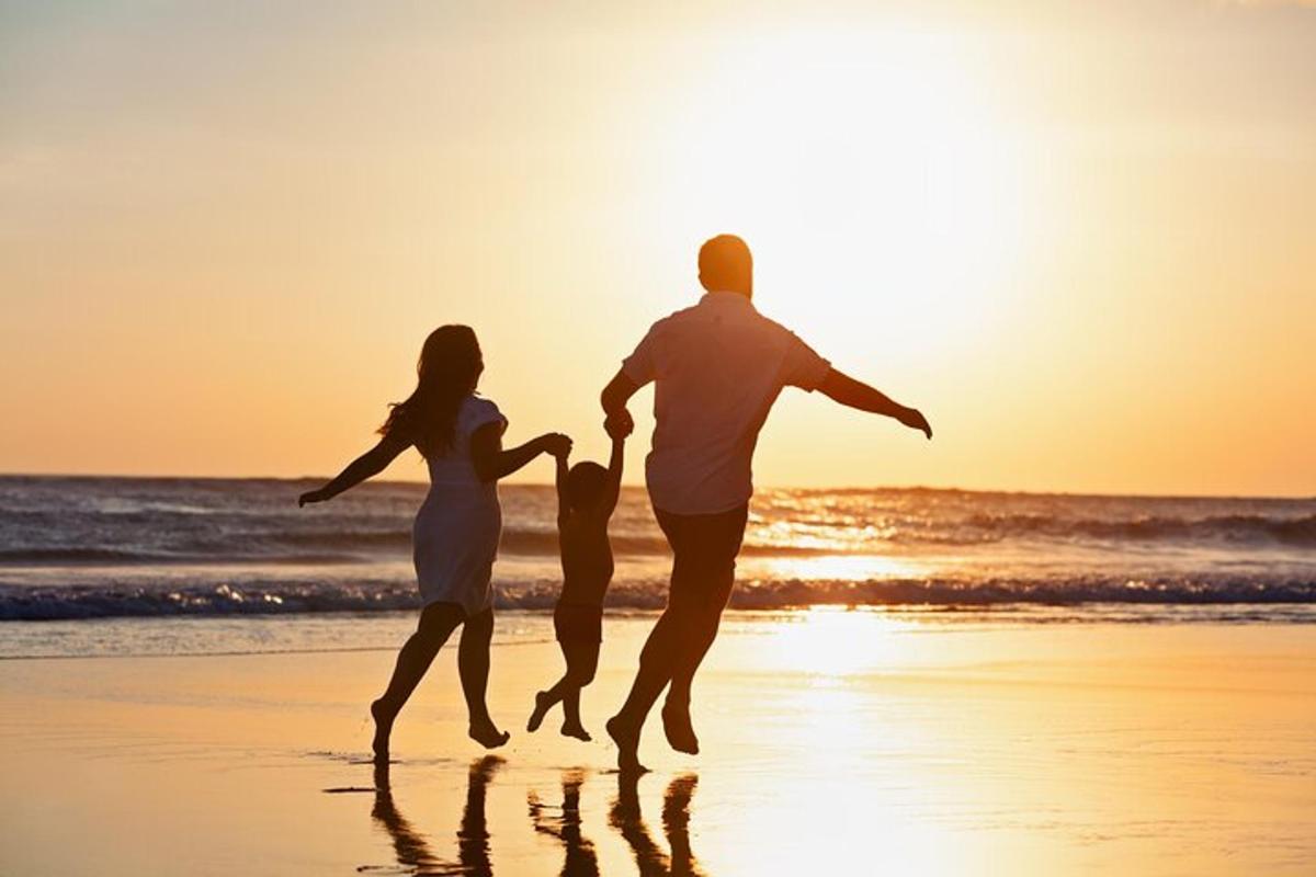 rodzina biegnąca po plaży o zachodzie słońca