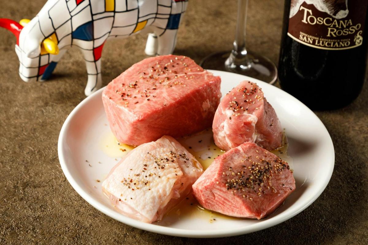 un piatto di cibo con carne e una bottiglia di vino