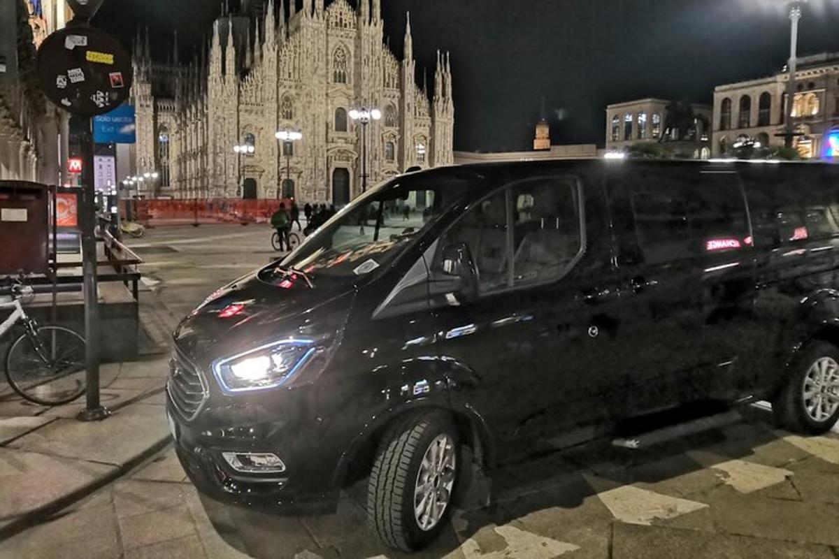 musta pakettiauto pysäköitynä suuren rakennuksen eteen