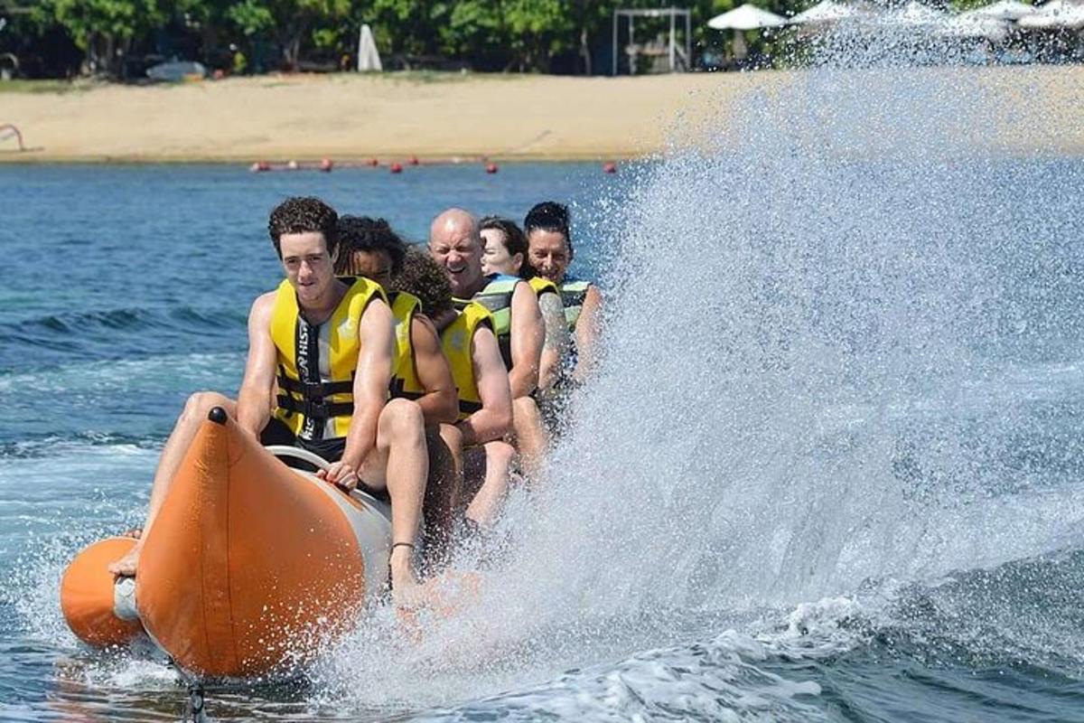 a group of people riding on an orange raft in the water