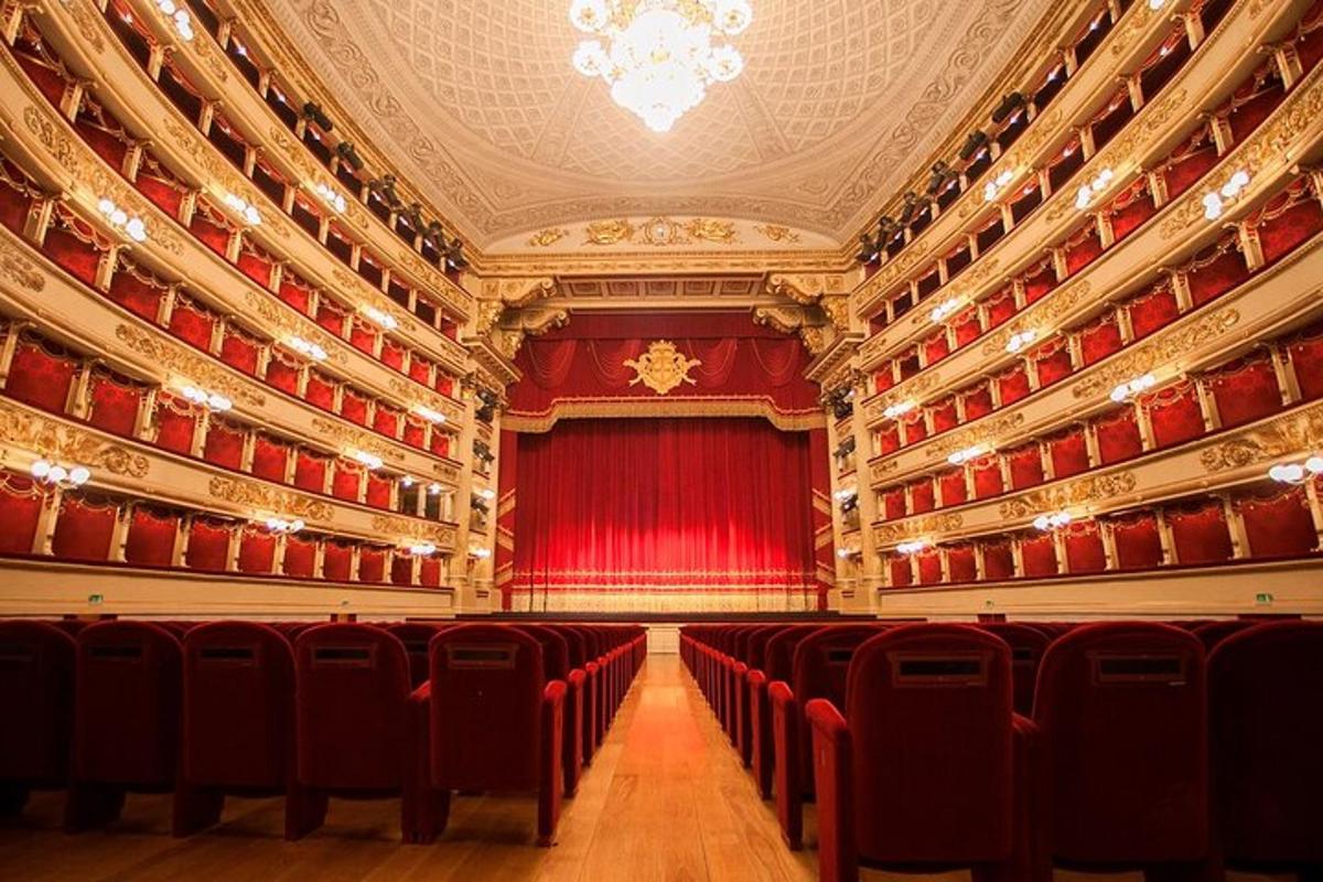 un grande auditorium con sedie rosse e una tenda rossa