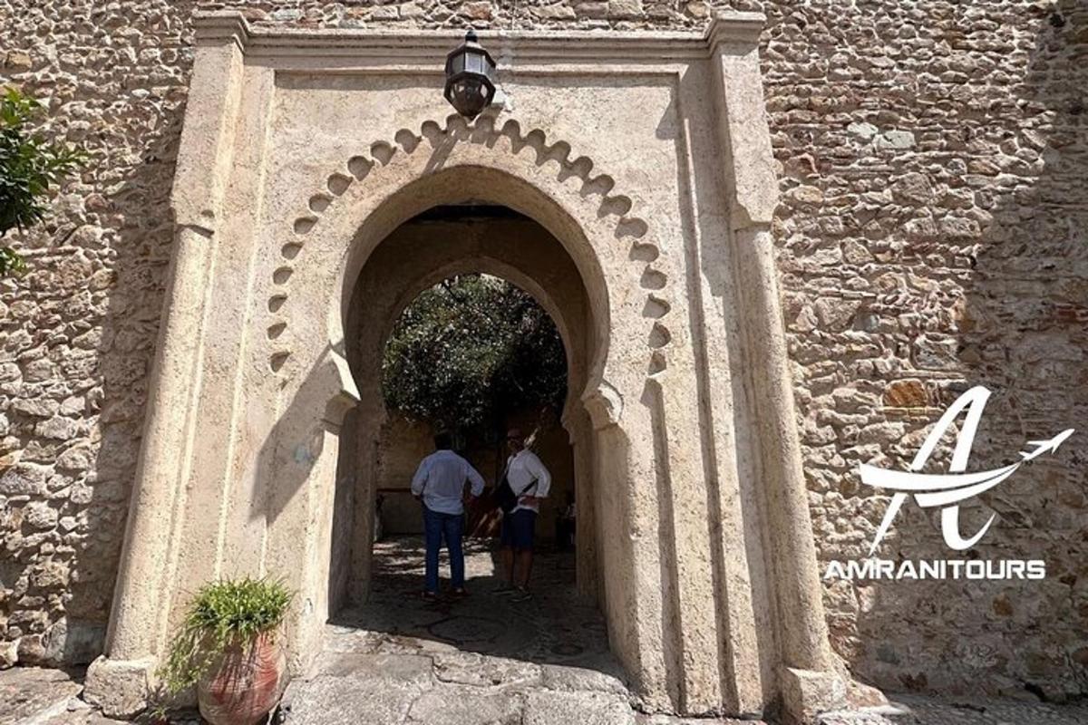 Δύο άτομα που περπατούν μέσα από μια αψίδα σε ένα κτίριο
