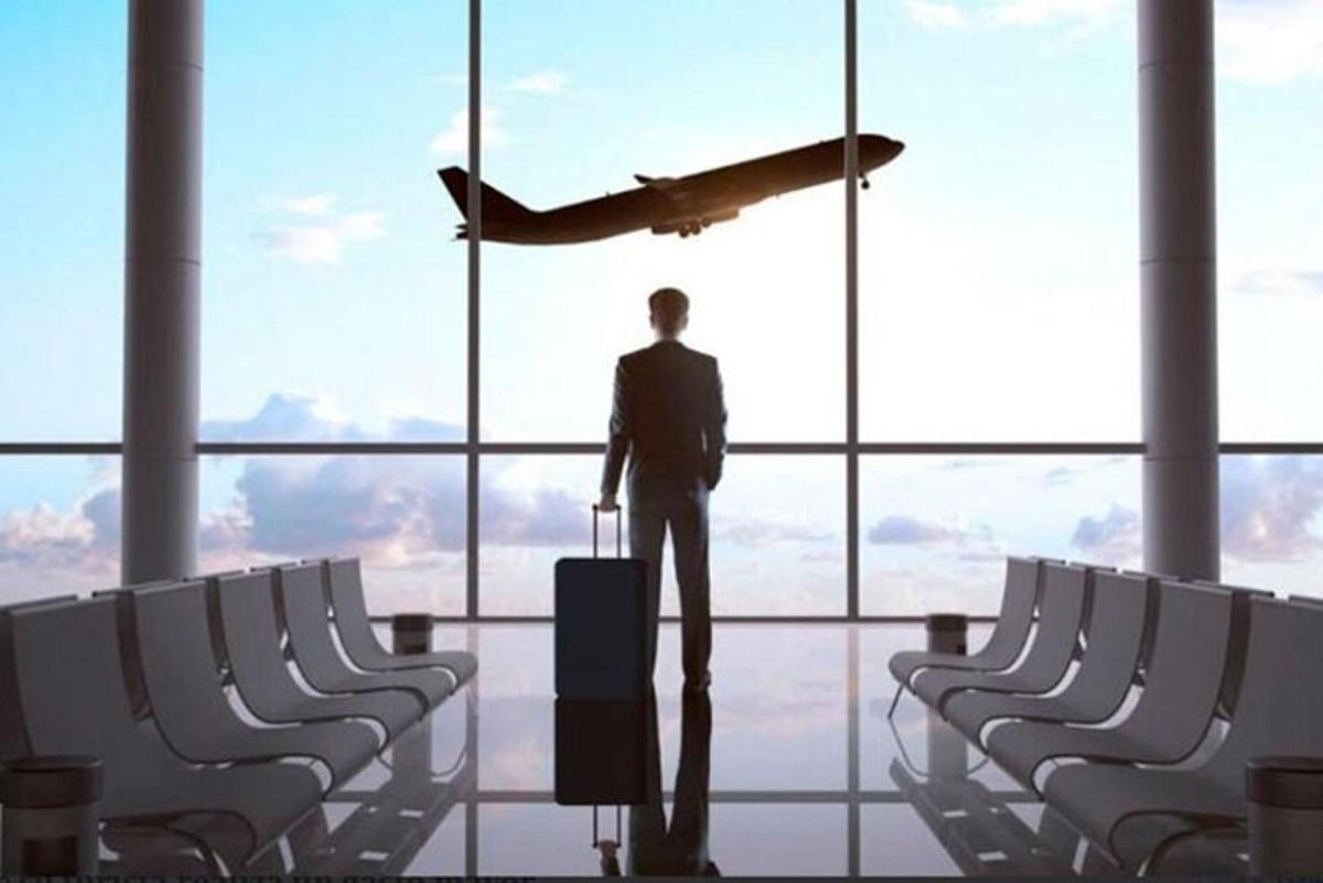 en mann som står på en flyplass og ser på et fly