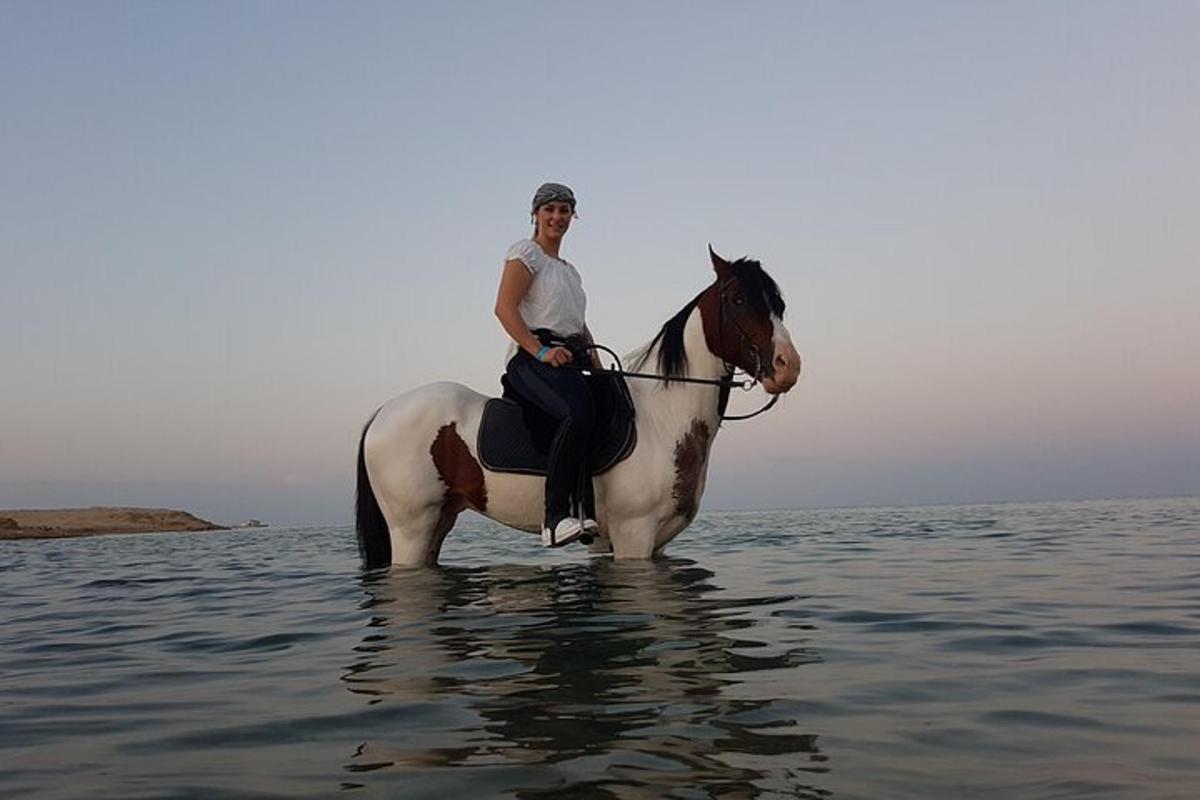 ein Mann, der auf einem Pferd im Wasser reitet