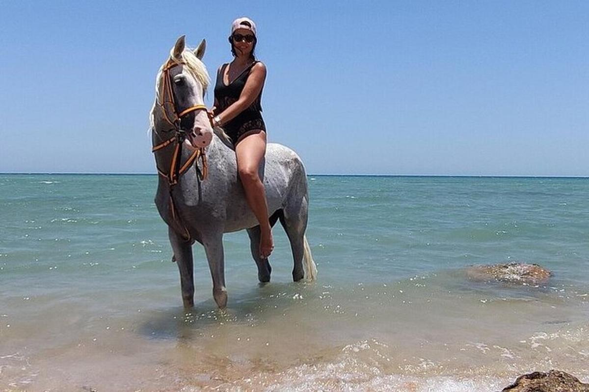 seorang wanita menunggang kuda di pantai