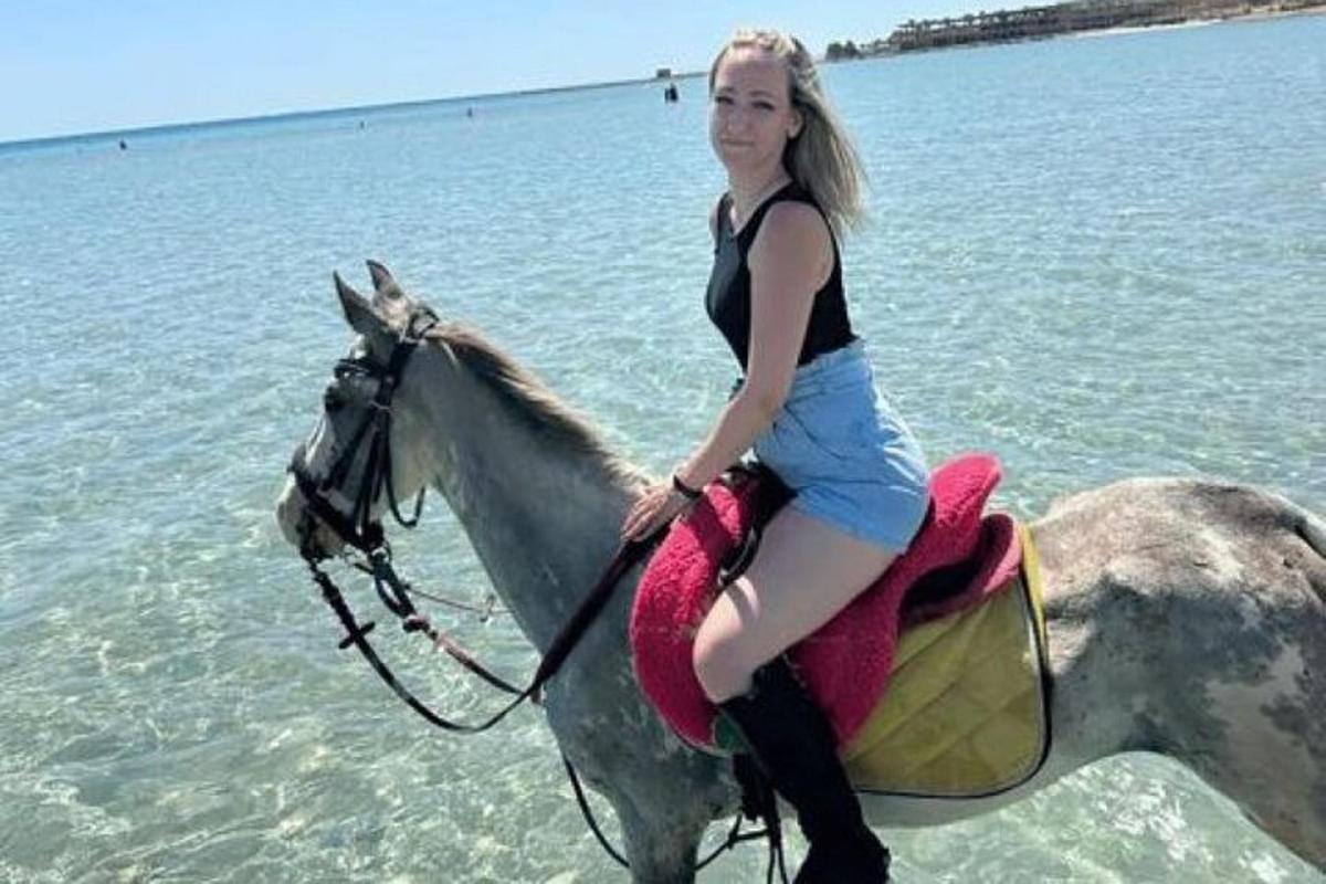 a young woman riding a horse in the water